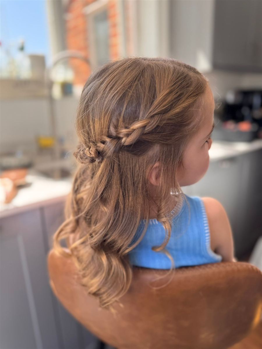 Flower girl braided half-up style with soft curls