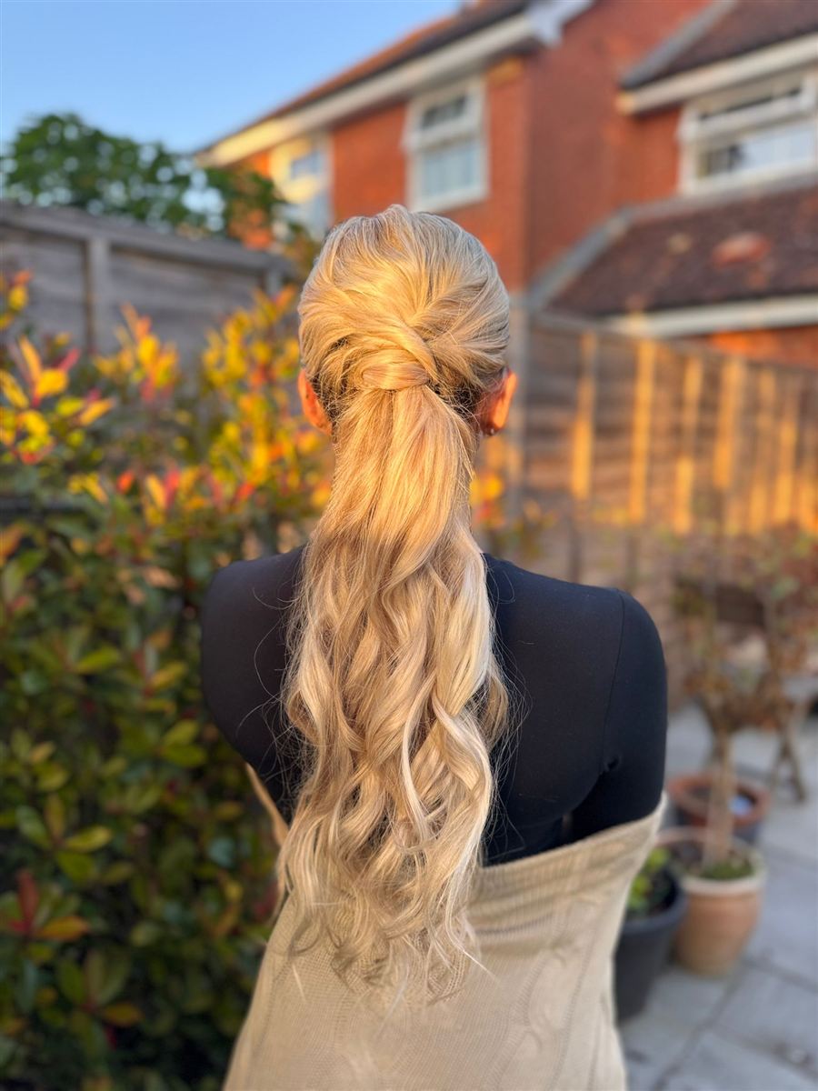 Twisted golden ponytail with long loose waves at sunset
