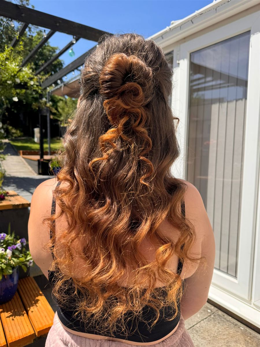 Prom half-up style with rose bun and long tumbling curls